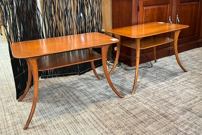 Two wooden side tables on a carpeted floor with a decorative wall in the background.